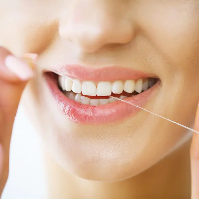 Person brushing and flossing teeth properly